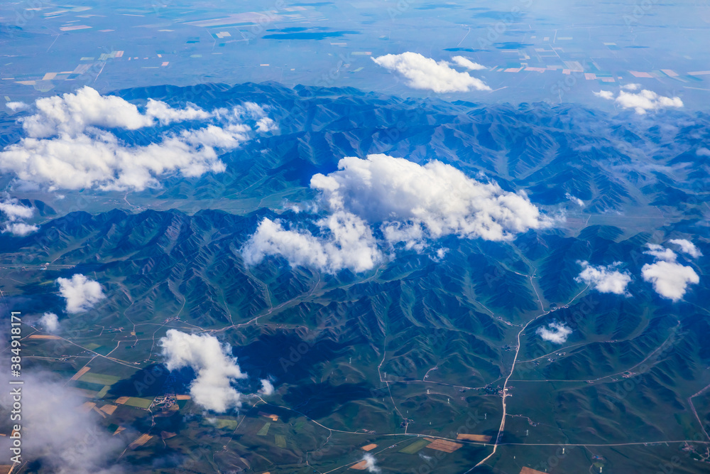 Aerial view above the clouds and mountain peaks on a sunny day.mountain view from airplane.