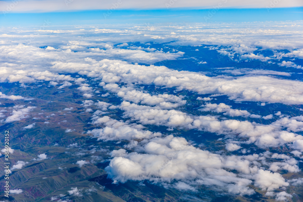 Aerial view above the clouds and mountain peaks on a sunny day.mountain view from airplane.