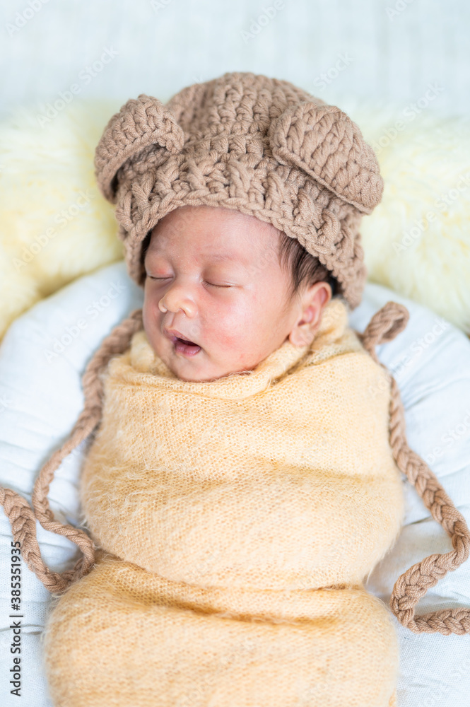 Newborn baby in costume sleeping in baby case