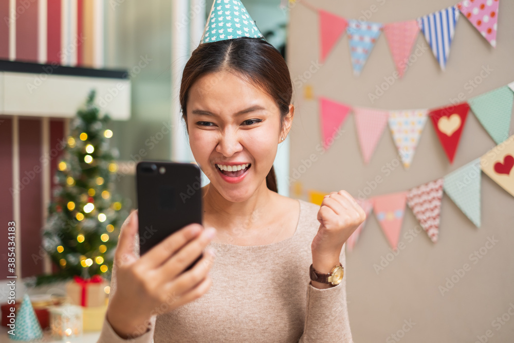 Happy Asian woman using mobile phone for shopping, video call conference with friend and family duri