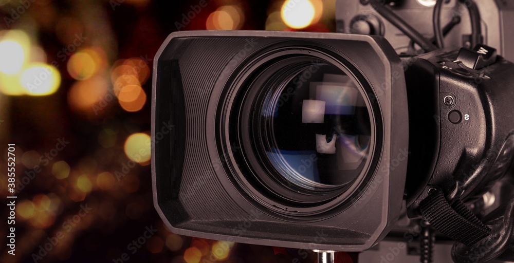 Professional video camera on dark bokeh background