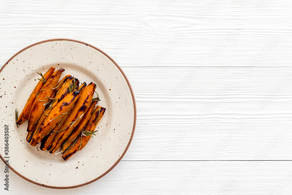 Sweet potato fries with spices on a wooden board, top view