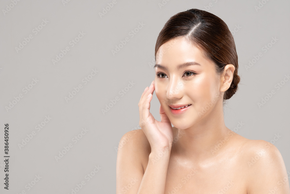 美丽的亚洲女人抚摸着柔软的脸颊，微笑着干净清新的皮肤，幸福快乐的智慧