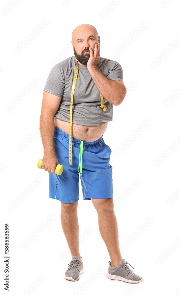 Annoyed overweight man with measuring tape and dumbbell on white background. Weight loss concept