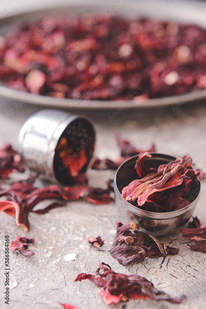 Strainer with dry hibiscus tea on table