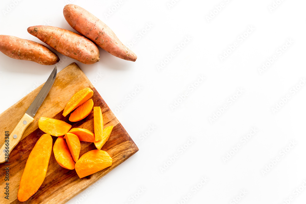 Sweet potato - sliced yams organic vegetables on cutting board, view from above