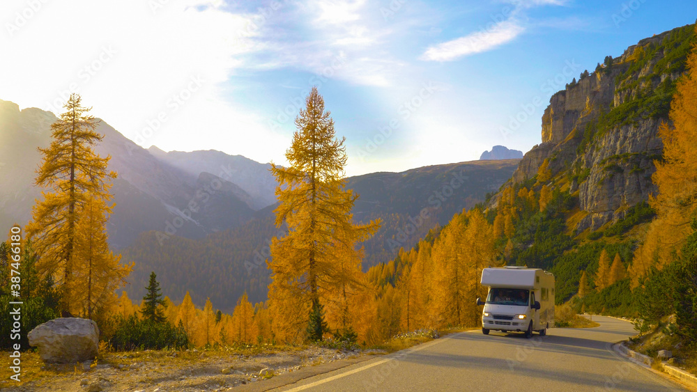 一个阳光明媚的秋天，一辆白色房车驶上空旷的山路