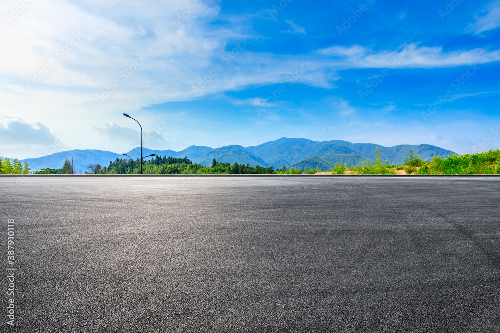 Race track road and green plants with mountain natural scenery in Hangzhou on a sunny day.