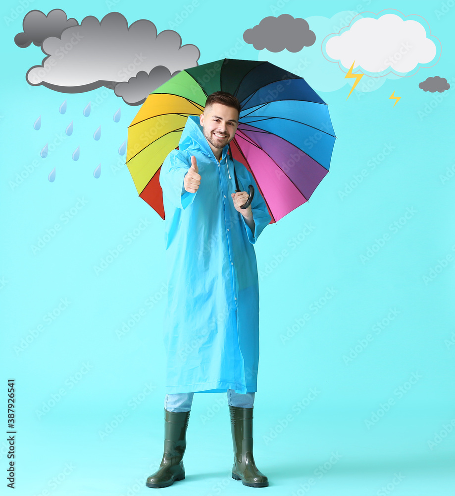穿着雨衣的年轻人在彩云背景下撑着伞