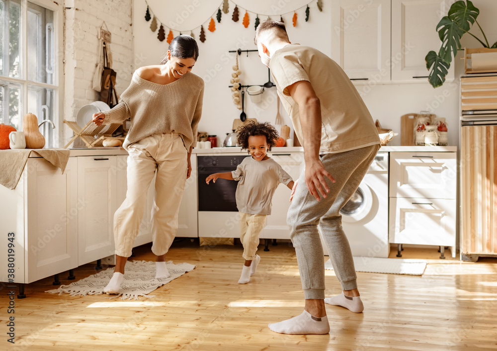 Energetic multiracial family playing in kitchen.