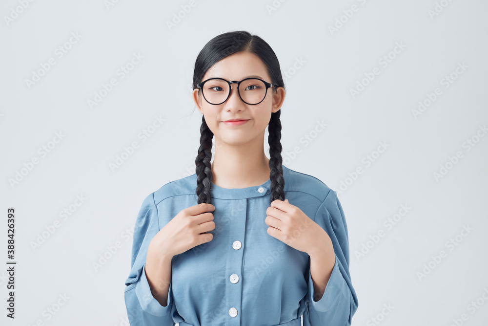 Cute girl teenager with two pigtails hair braids holding hands and posing for camera