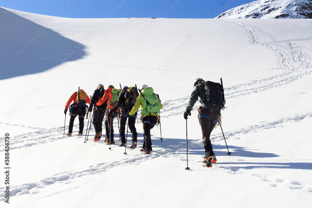 Rope team mountaineering with crampons on glacier Sexegertenferner towards Sexegertenspitze and moun