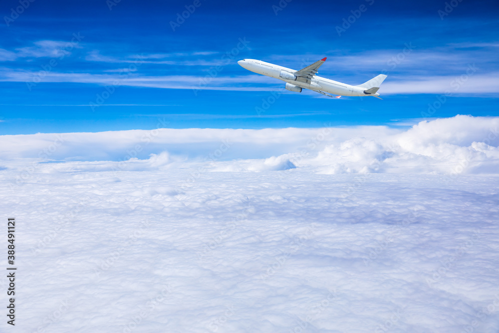 商用飞机在蓝天白云之上飞行。