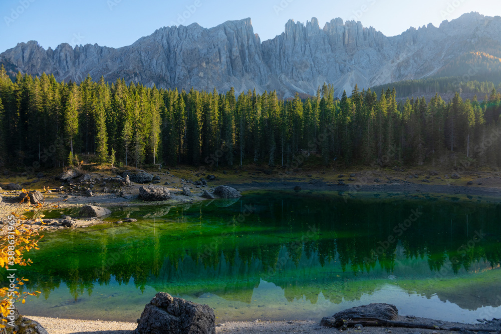 Breathtaking view of an untouched lake Carezza under the Dolomites on sunny day.