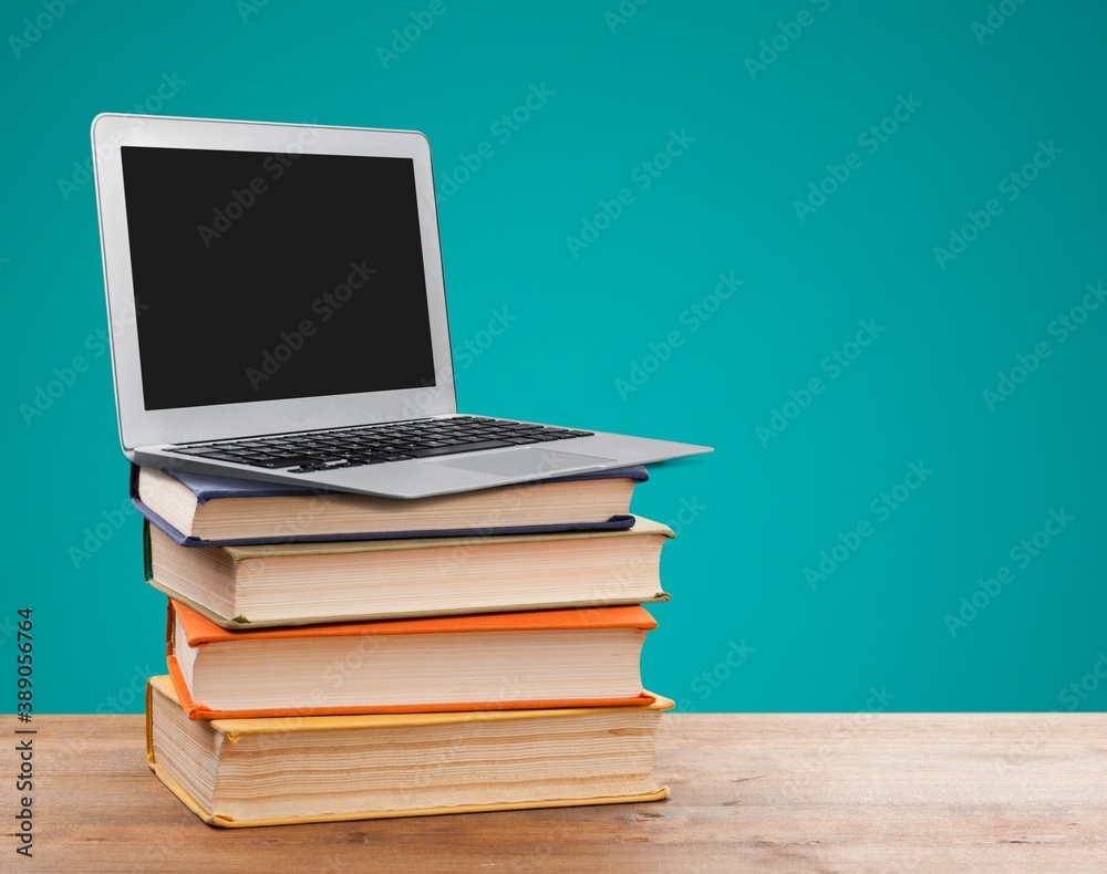 Stack of school books and laptop, education and learning concept