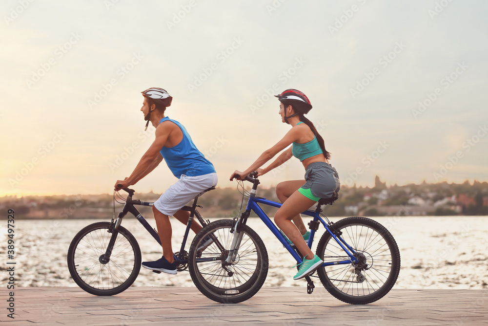 河边骑自行车的运动型年轻自行车手