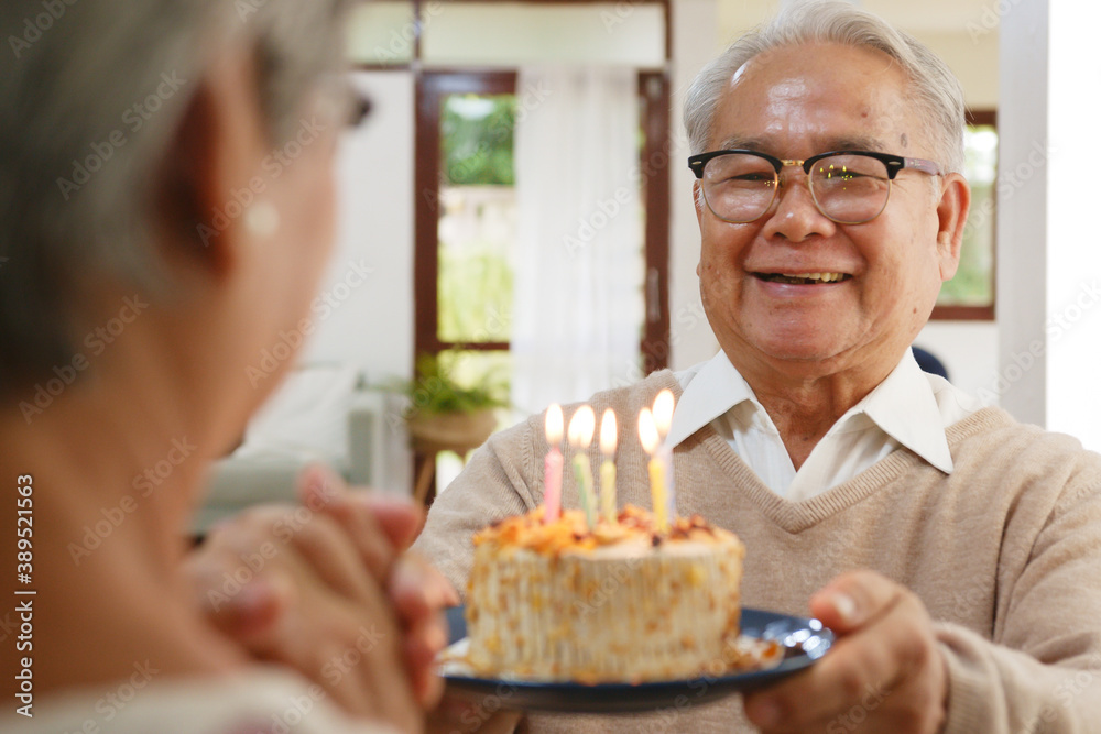 亚洲资深男士为资深女士送上生日蛋糕庆祝，幸福快乐，退休f