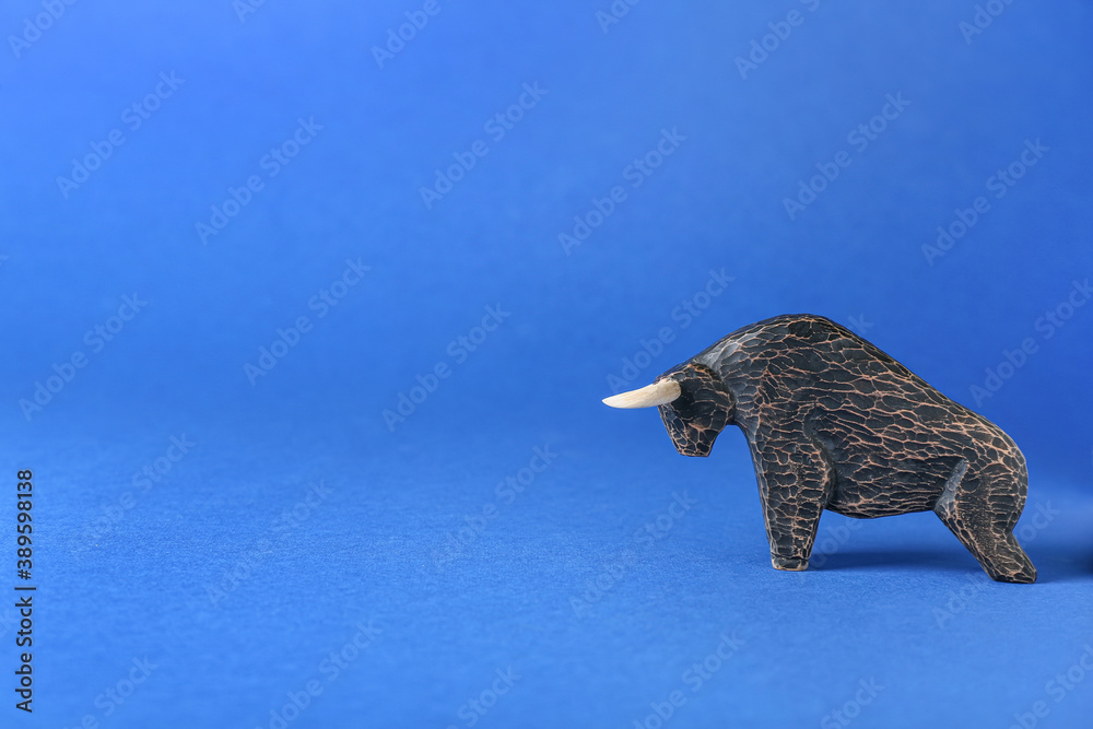 Figurine of bull as symbol of year 2021 on color background
