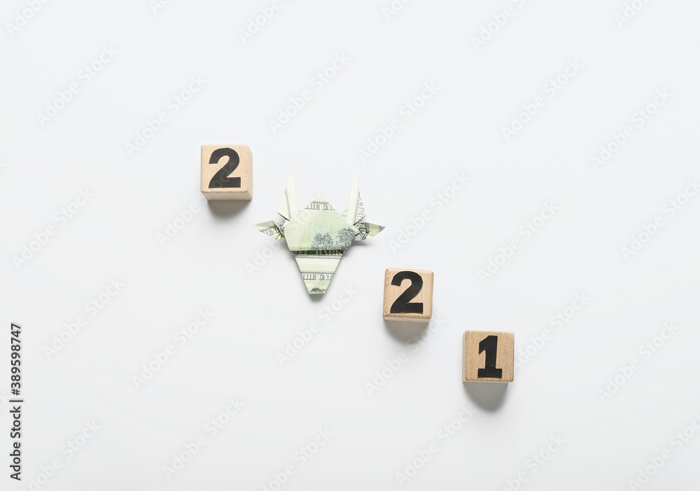 Figure 2021 made of cubes and origami bull as symbol of the year on white background