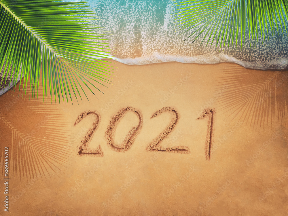 Happy New Year 2021, lettering on the beach with wave and blue sea. Numbers 2021 year on the sea sho