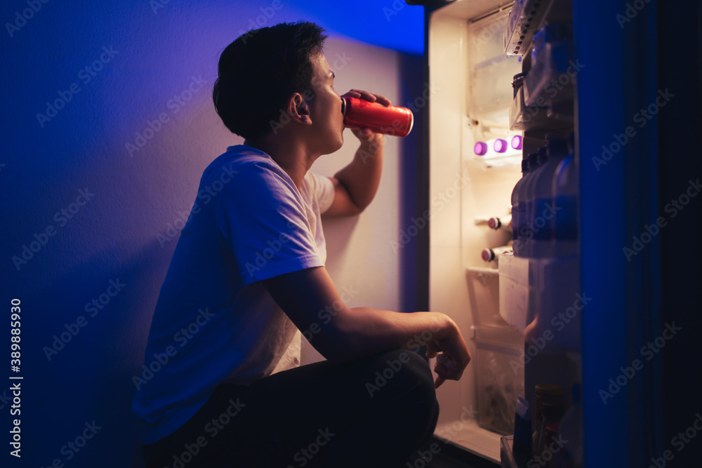 Asian men he is opening the refrigerator.Drink soft drinks at night