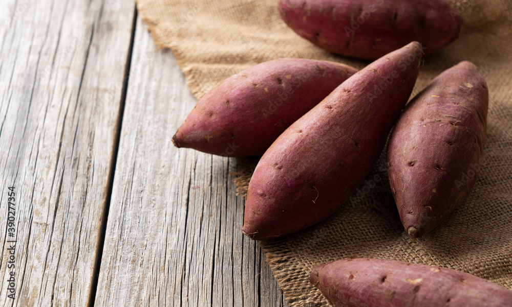 Sweet potatoes on an old wooden background