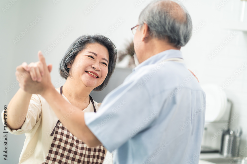 亚洲高级情侣在厨房跳舞，退休生活幸福。