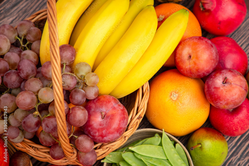 将蔬菜和水果苹果、葡萄、橙子和香蕉与胡萝卜放在木篮子里。