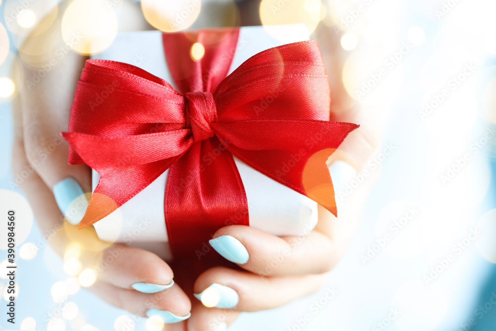 一个女人拿着一个礼盒做着礼物的手势。