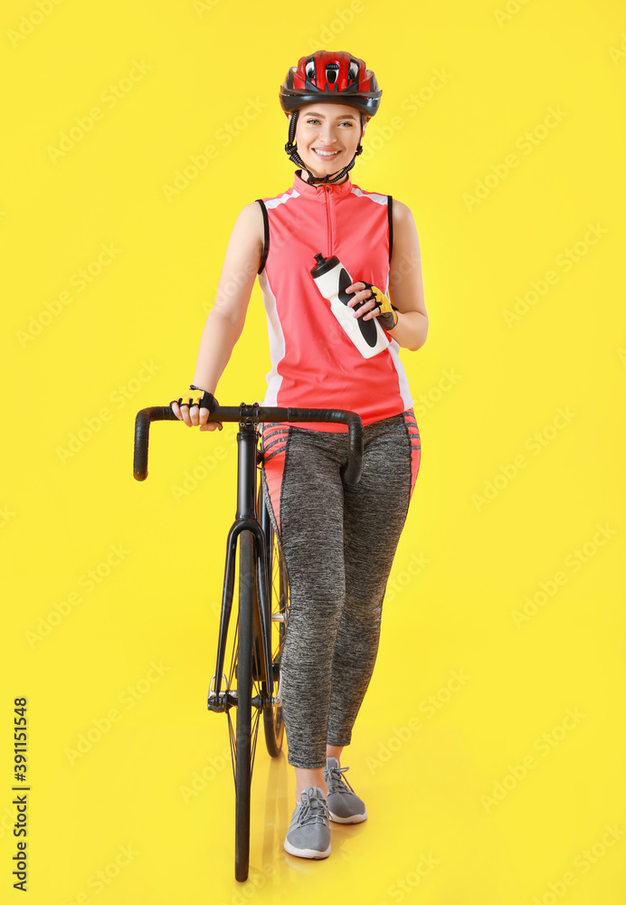 彩色背景上有自行车和水的女自行车手