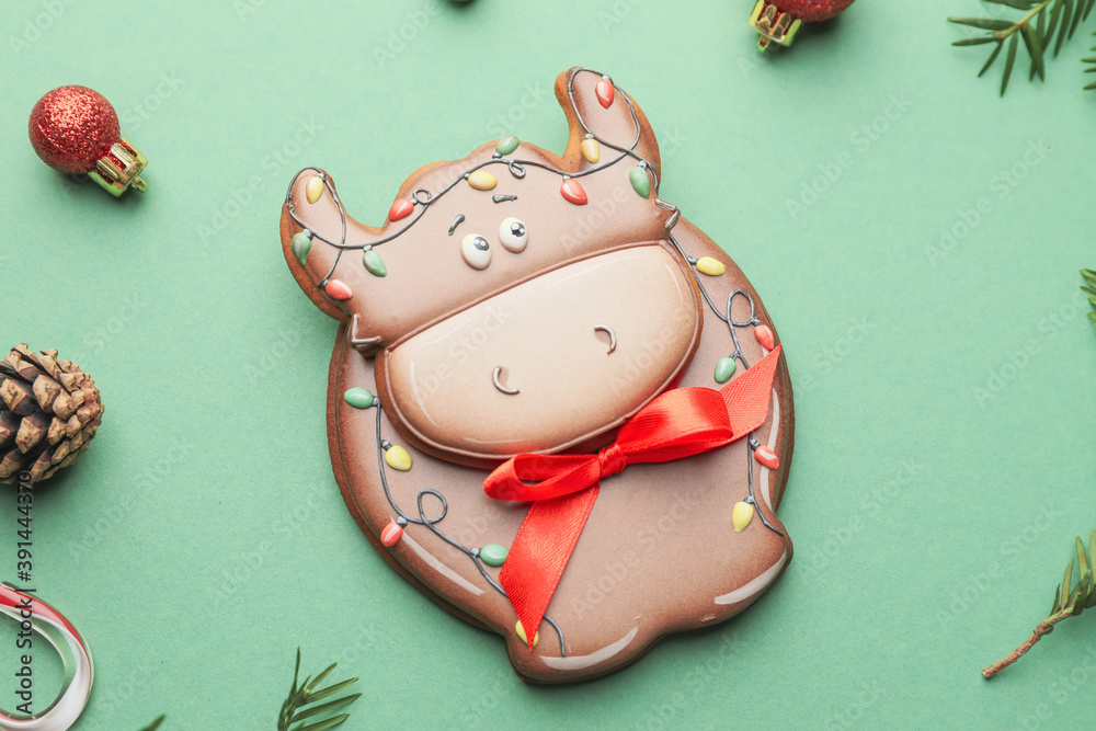 公牛形状的美味饼干和彩色背景上的圣诞装饰