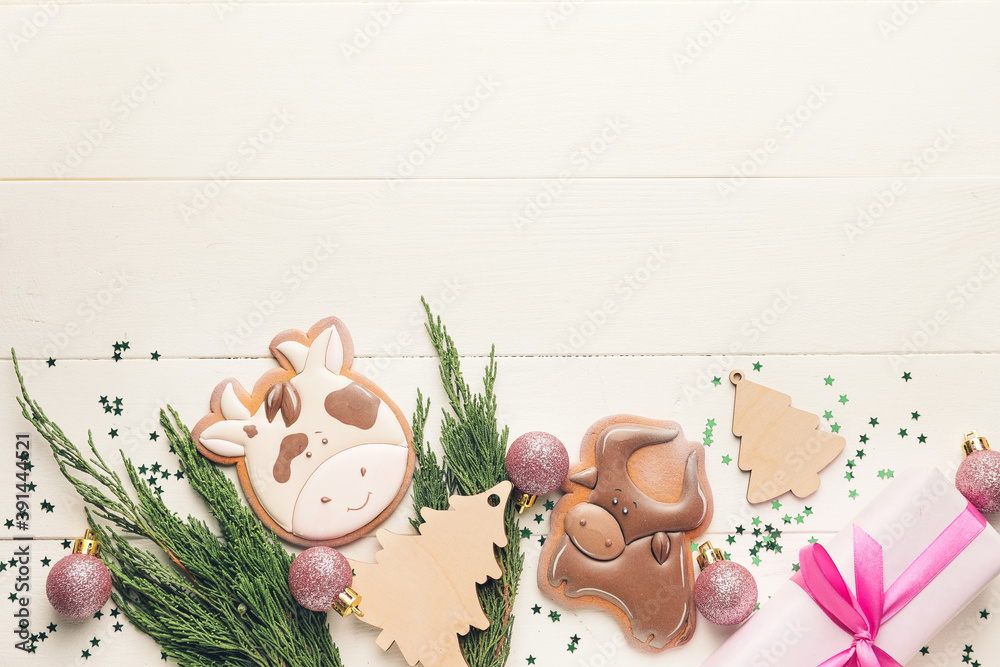 白色木质背景上的公牛形状和圣诞装饰的美味饼干