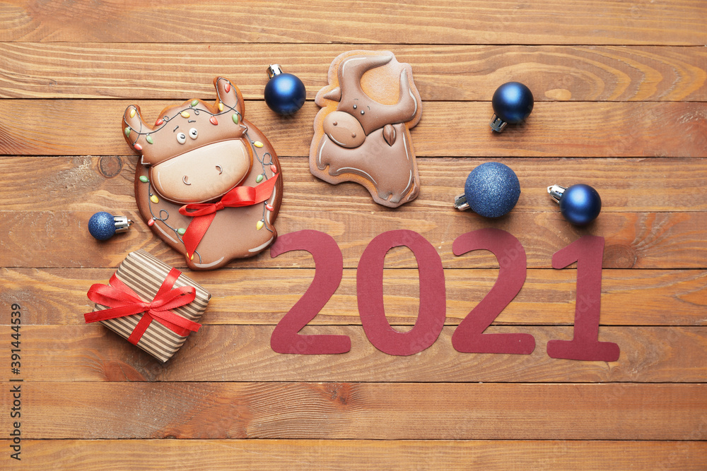 公牛形状的美味饼干和木制背景上的圣诞装饰