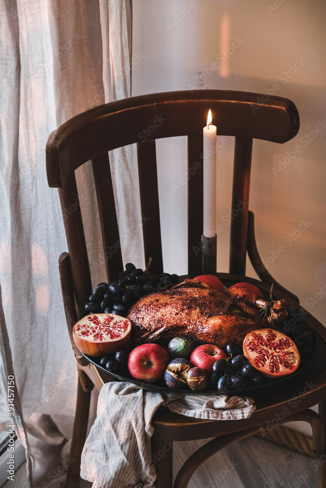 感恩节或圣诞派对用全烤箱烤鸭子配时令水果和蜡烛