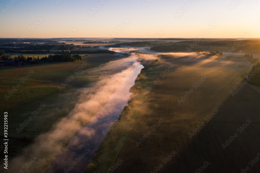 Aerial view of fog above a river valley at dawn