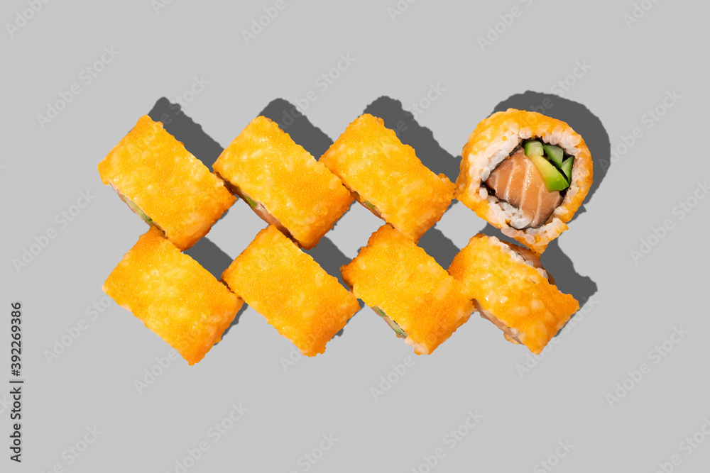 隔离在灰色背景上的寿司卷。三文鱼卷配鳄梨、鱼子酱和黄瓜。日本食品