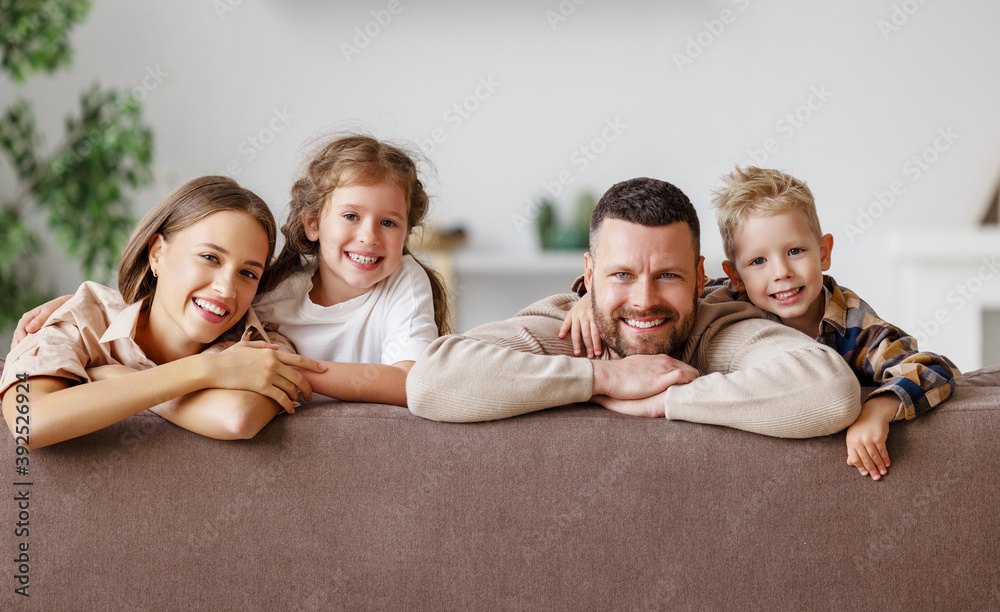 幸福的家庭母亲父亲和孩子在家里的沙发上。