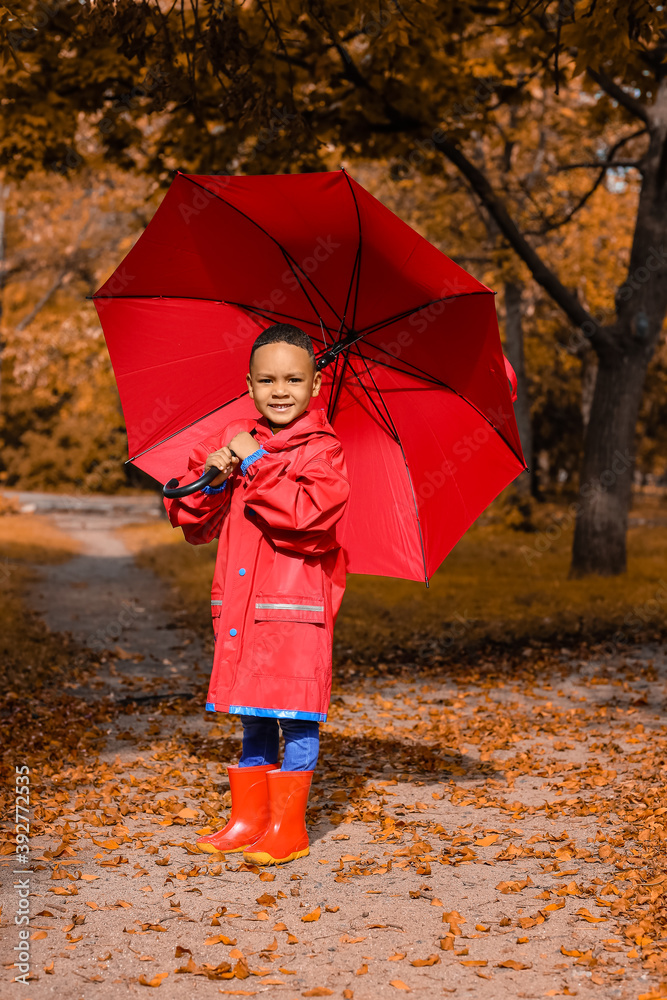 秋天公园里带伞的可爱非裔美国男孩