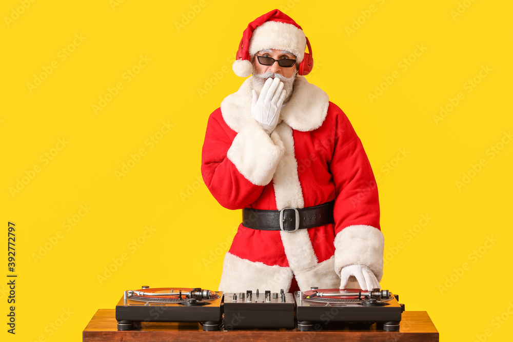 酷酷的圣诞老人DJ在彩色背景上播放音乐