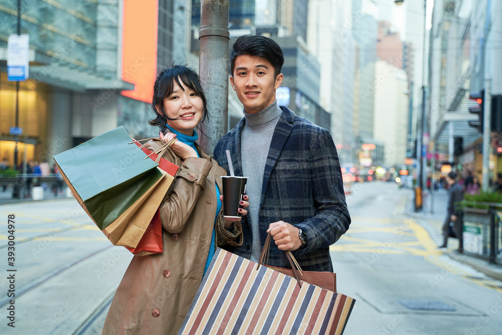 年轻的亚洲夫妇拿着购物袋的户外肖像