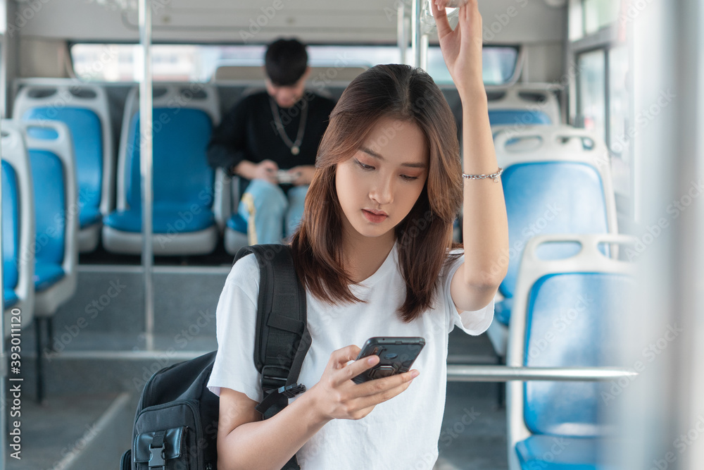 亚洲女性在公交车上使用智能手机