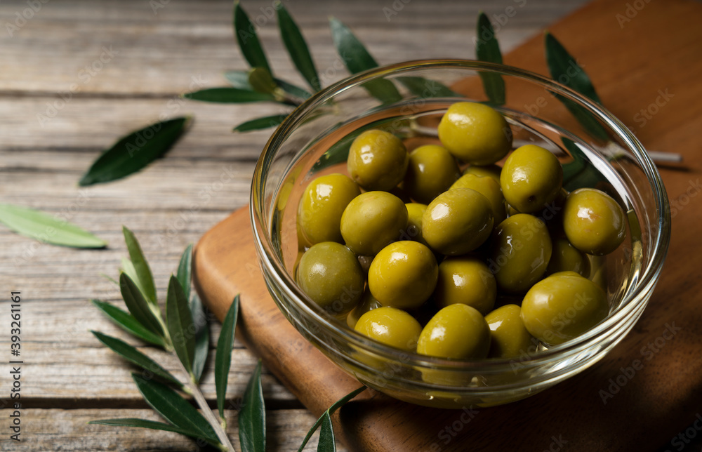 Olive branches with salted olives placed on a background of old wooden planks