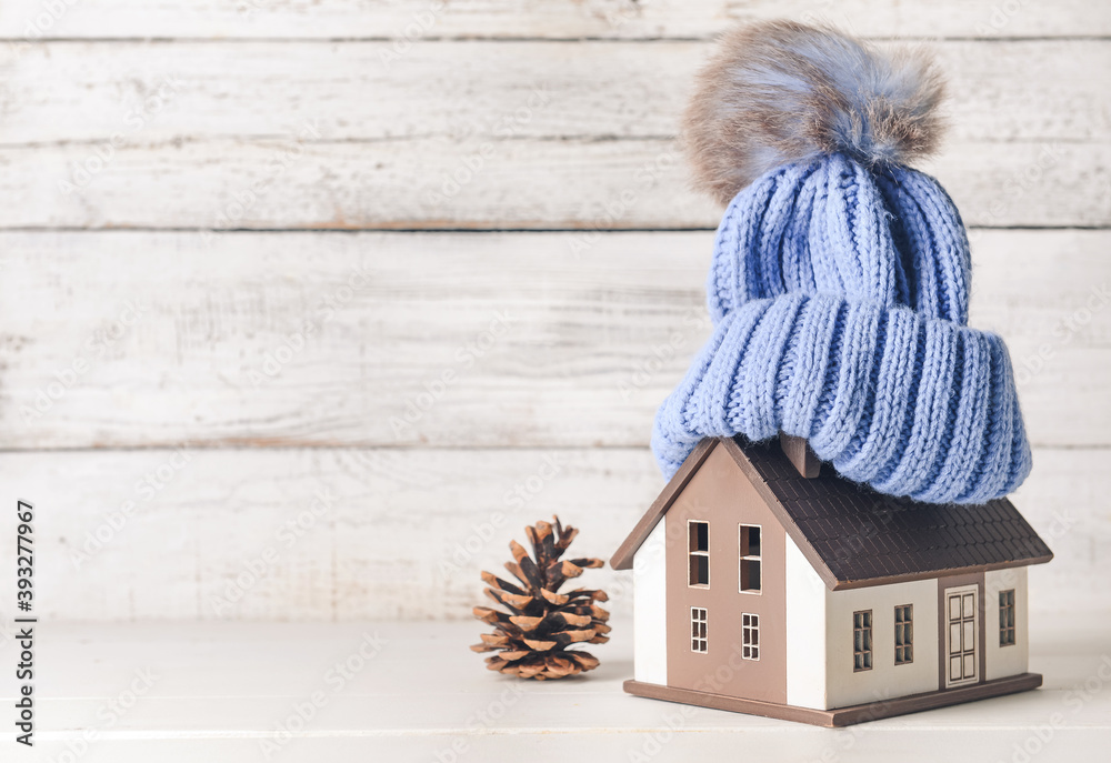 房子和桌子上的暖帽的形状。供暖季节的概念