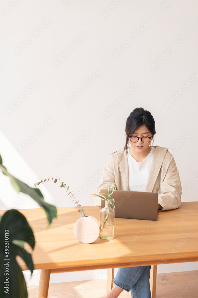 快乐的亚洲女人在家用笔记本电脑工作