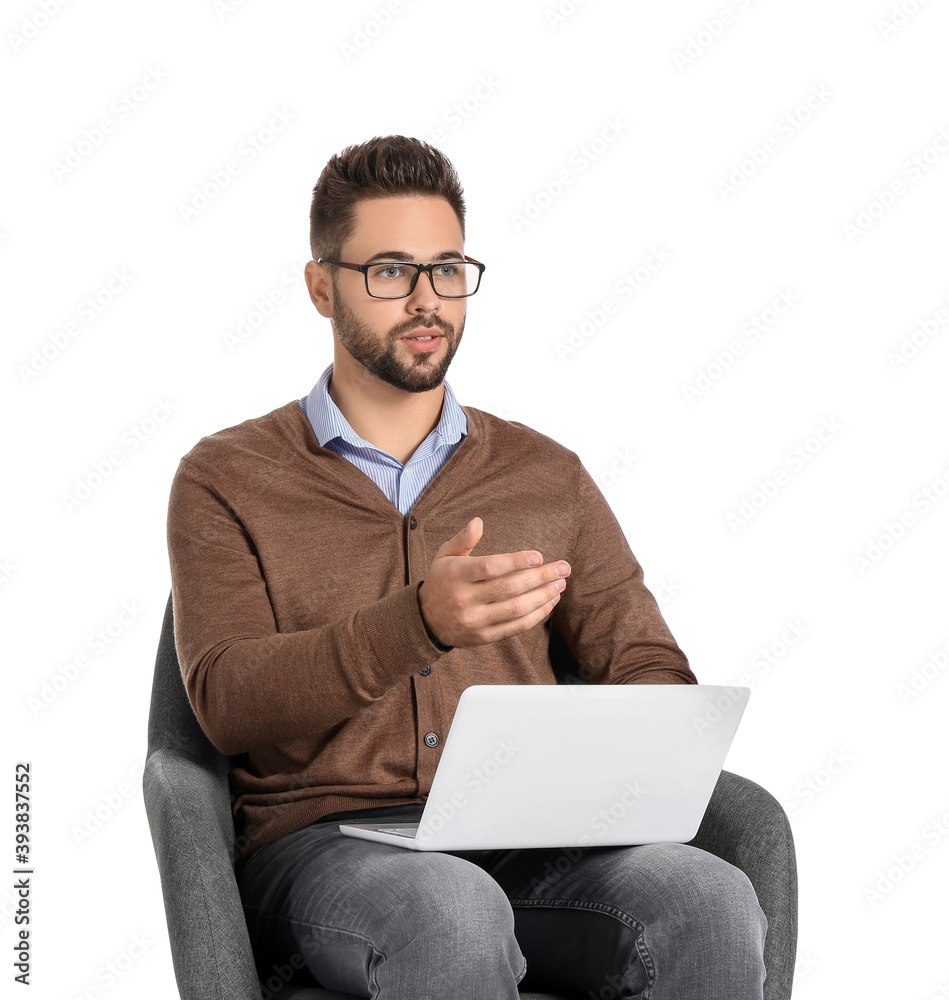 白人背景下坐在扶手椅上的带笔记本电脑的男性心理学家