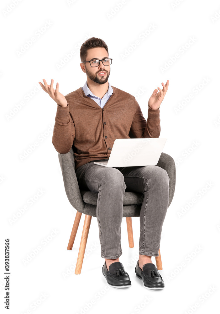 带笔记本电脑的男性心理学家坐在白底扶手椅上