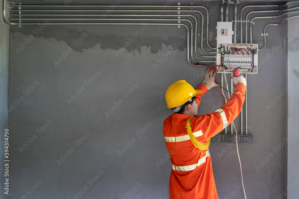 Asian electrician wear safety clothes with electric screwdriver installations and wires on relay pro