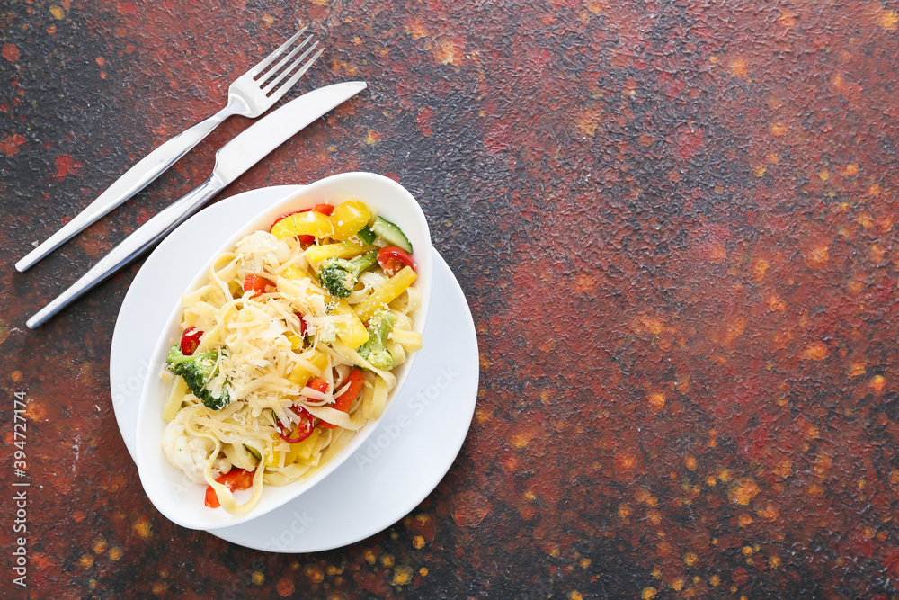 Plate with tasty pasta primavera on color background