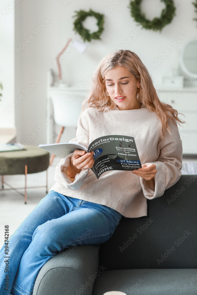 穿着保暖毛衣的漂亮年轻女人在家看杂志