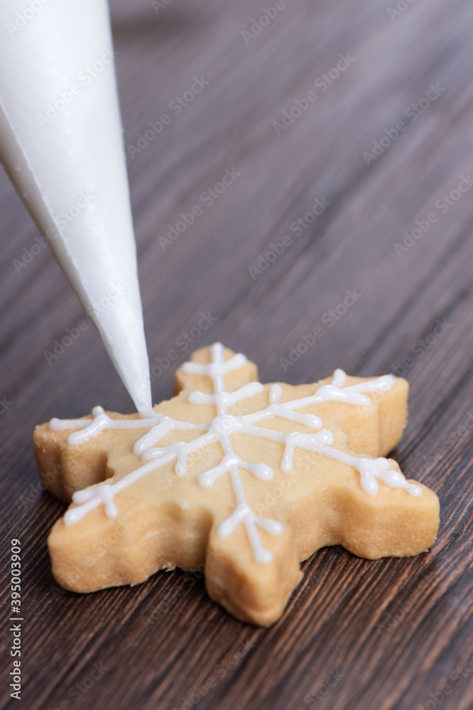 在木桌背景上画圣诞雪花糖曲奇的特写，上面有糖霜。
